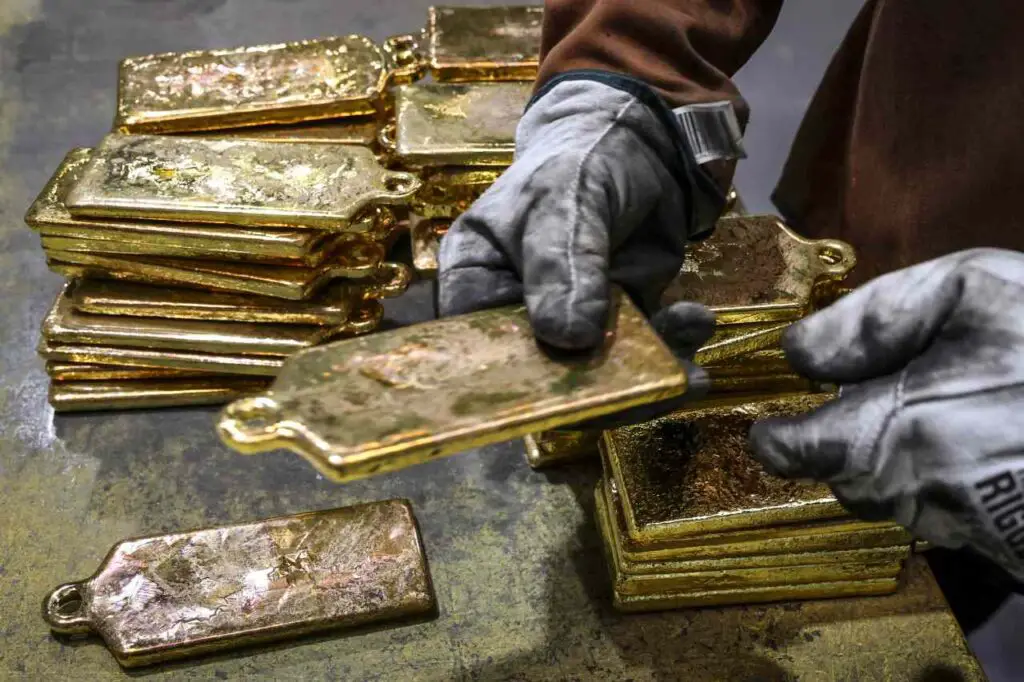 Hand in gloves holding a gold slate